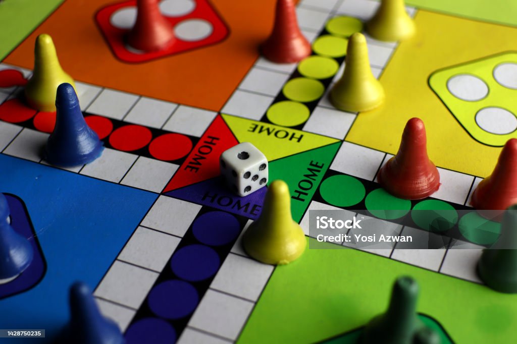 playing board games with dice, colorful board and pieces playing board games with dice, colorful board and pieces. red, blue, yellow and green. strategy games. Board Game Stock Photo
