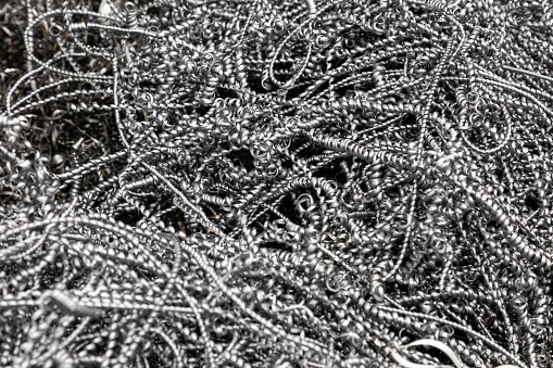 Steel shavings. Industrial background. Metal shavings after working on a milling machine or CNC machine. Metal shavings texture. industrial garbage