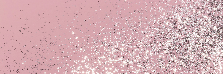 Sparkling silver glitter on pink background banner texture. Abstract holiday blurred lights header. Wide screen wallpaper. Panoramic web banner with copy space for design