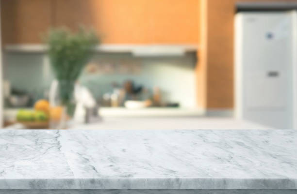 istock Selective focus,Marble table top on blur white kitchen room background. 1428753235