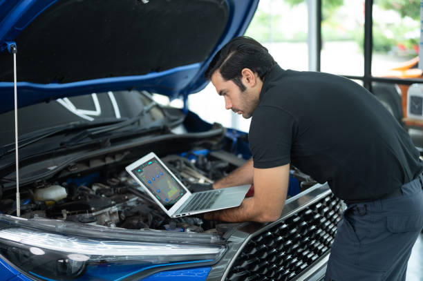 istock Mechanic Asian man close up using laptop computer and diagnostic software to tuning fixing repairing car engine automobile vehicle parts using tools equipment in workshop garage support services 1428754714
