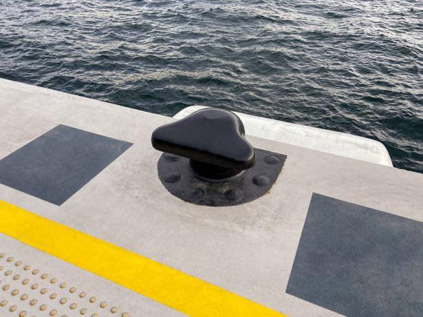 Mooring line with a bollard in the coastline Mooring line with a bollard in the coastline, a bollard in the commercial dock mooring line stock pictures, royalty-free photos & images