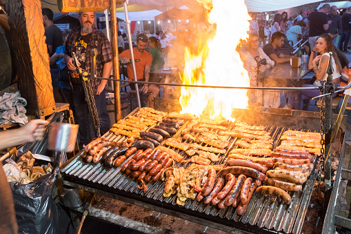 Castilla La Mancha, Spain - September 03, 2022: Grill of meats and sausages in an open-air tavern of the Medieval Fair of the town of Buitrago del Lozoya