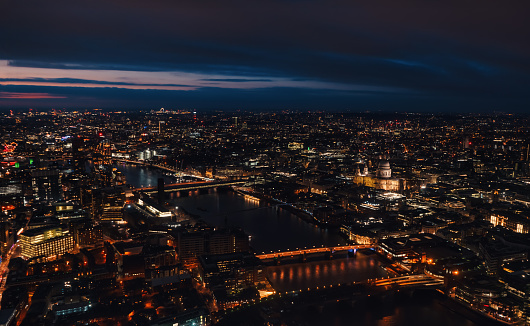 Aerial view of north east part of London, in evening. St Pauls Cathedral visible over river Thames.