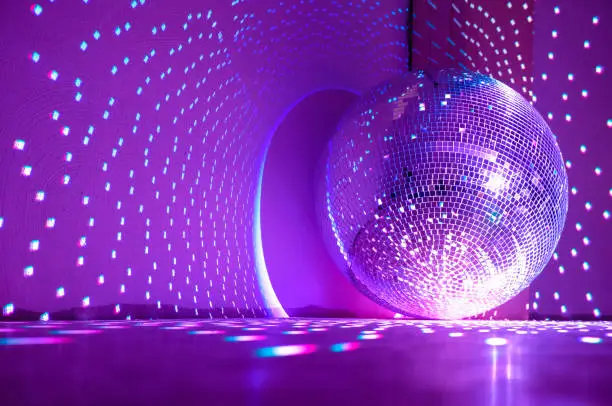 Disco ball reflecting purple light. Holidays concept. Copy space.