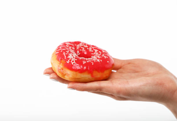 istock Woman hand holds red donut over white 1428767436