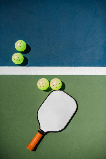 Pickleball court, paddle and balls Pickleball is one of the fastest growing sports. Photo includes paddle and pickleballs. pickleball equipment stock pictures, royalty-free photos & images