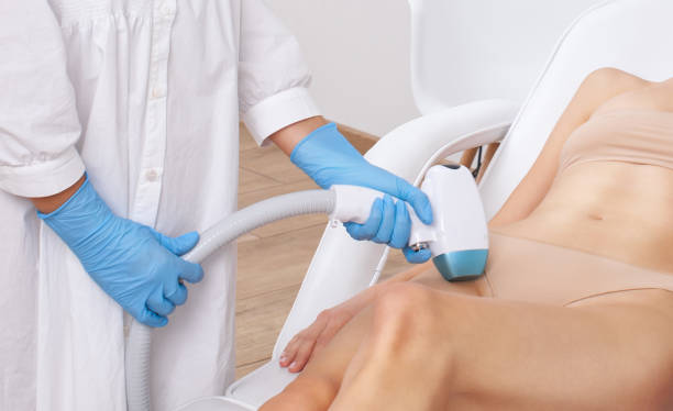 Elos epilation, hair removal procedure on a womans body. Beautician doing laser rejuvenation in a beauty salon. Removing unwanted body hair. Hardware ipl cosmetology stock photo