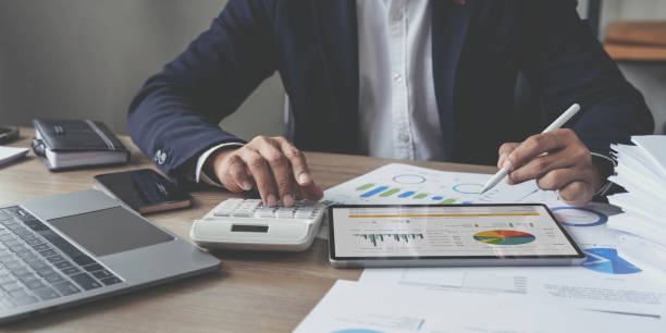 istock businessman writing business plan at desk in modern office. Planning analyze investment, business strategy and marketing, using graph chart and digital tablet. 1428775673