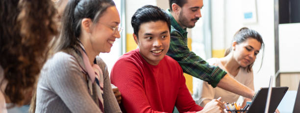 istock Horizontal banner or header with young co-workers multiethnic team planning a new startup - People working on a new project in creative coworking office - Bright filter with focus on asian man face 1428776475