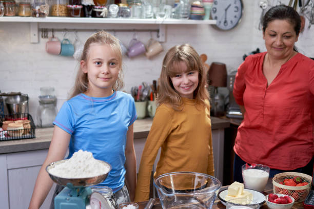 istock Young Mother Preparing Waffles with her Daughters in Domestic Kitchen 1428783209