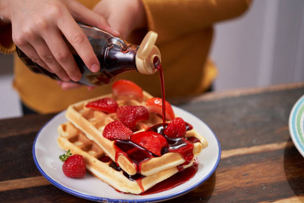 istock Young Girl Preparing Waffles with Fresh Berries in Domestic Kitchen 1428783381