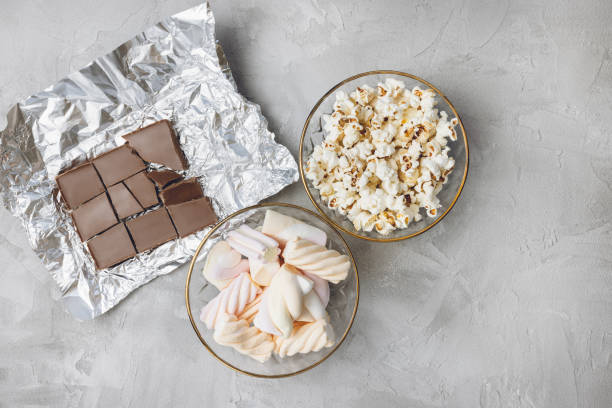 Popcorn, marshmallow, chocolate bar pieces in bowls. Ingredients for cooking, copy space