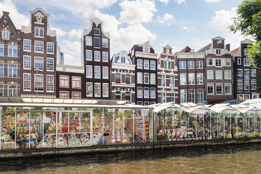Amsterdam floating flower market and tall narrow canal houses.