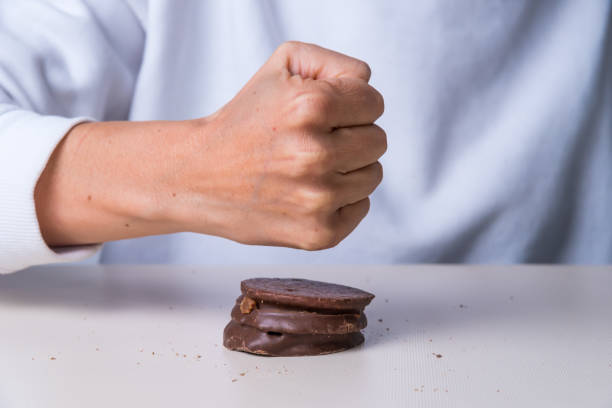 istock fist clenched and a chocolate, sugar, not suitable for diabetics 1428786993