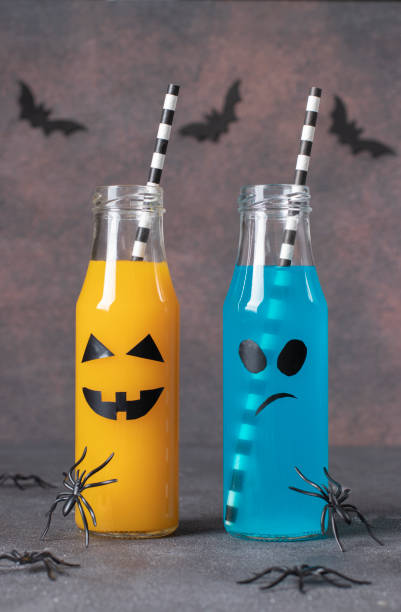 istock Two Colorful Halloween drinks in bottles for kids party on brown background, Vertical image 1428788231