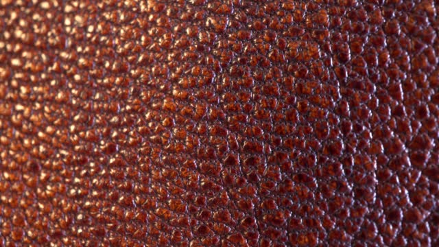 Part of a woman's boot. Slide shot of a detailed macro texture of a woman's leather boot. Slow Dolly Shot. Brown leather shoe surface.