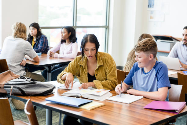 istock Female college student explains biology assignment to high school boy 1428801946