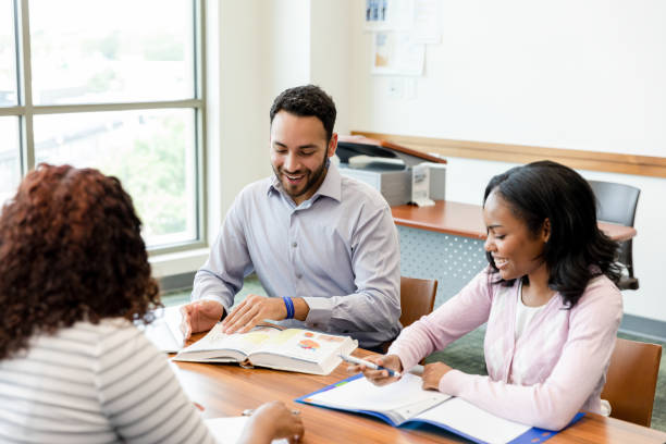 istock High school teacher goes over assignment with female students 1428801959