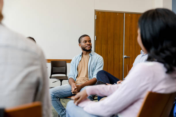 istock In group therapy, young man listens to unrecognizable counselor 1428801982