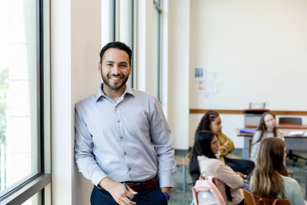 istock Male teacher smiles for camera in high school classroom 1428802000