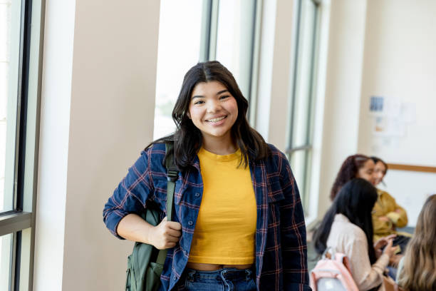 istock Female high school student smiles for camera before joining friends 1428802001
