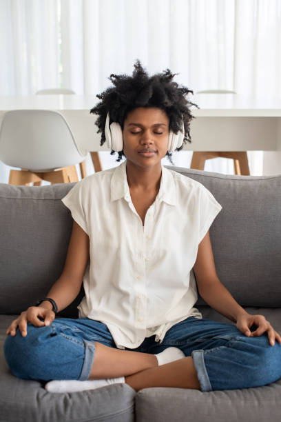 istock Peaceful woman with closed eyes meditating on sofa 1428805052