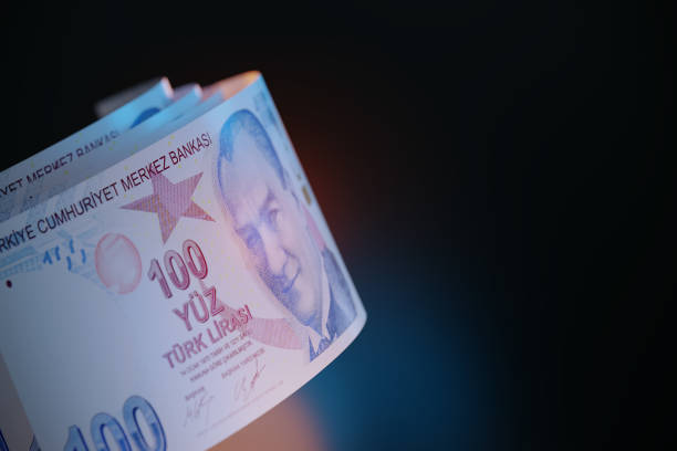100 turkish lira bills sitting over black background - türk lirası stok fotoğraflar ve resimler