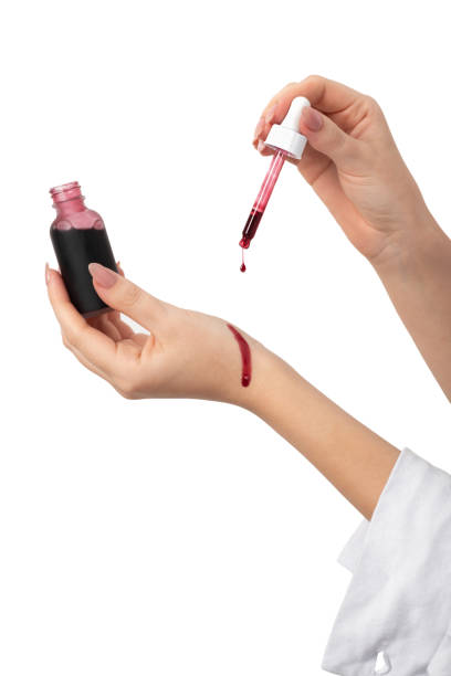 Woman holding pipette and applying skin red serum peeling aha bha acids to her hands
