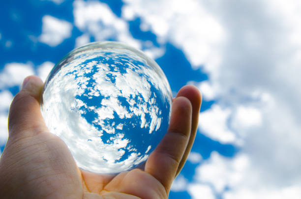 istock Blue sky with clouds in clear crystal glass ball. 1428806169