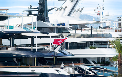 Antibes, France - September 27 2022 - Maritime flag of Malta floating on a mega yacht in the port of Antibes
