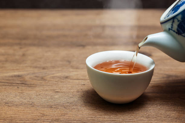 Oolong tea being poured into a teacup. stock photo