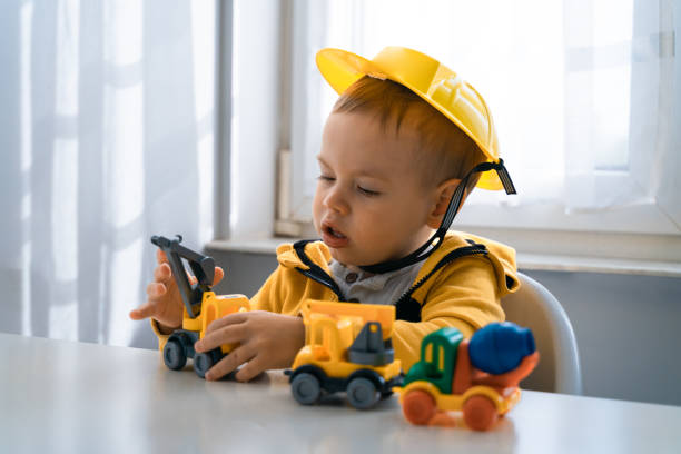 istock Child play with construction machinery at home, dreams to be an engineer. Little builder. Education, and imagination, purposefulness concept. Boy with digger 1428812435