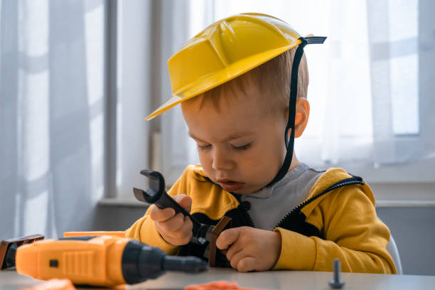 istock Child play with work tools at home, dreams to be an engineer. Little boy builder. Education, and imagination, purposefulness concept. Kid and wrench. 1428812456