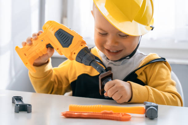 istock Child play with work tools at home, dreams to be an engineer. Little boy builder. Education, and imagination, purposefulness concept. Kid and drill 1428812471