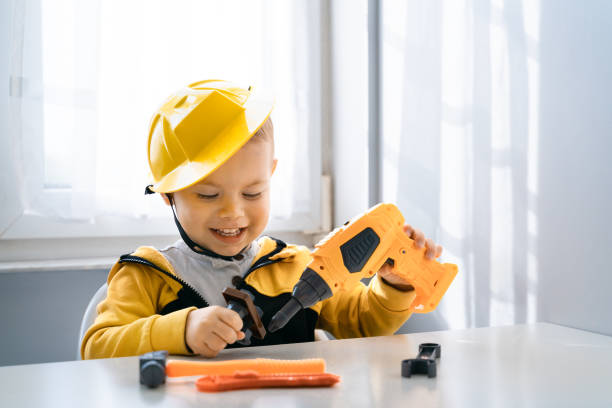 istock Child play with work tools at home, dreams to be an engineer. Little boy builder. Education, and imagination, purposefulness concept. Kid and drill 1428812472