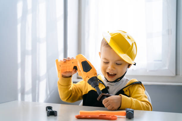 istock Child play with work tools at home, dreams to be an engineer. Little boy builder. Education, and imagination, purposefulness concept. Kid and drill 1428812474