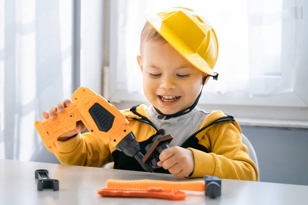 istock Child play with work tools at home, dreams to be an engineer. Little boy builder. Education, and imagination, purposefulness concept. Kid and drill 1428812478