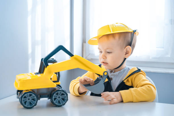 istock Boy with digger. Child play with excavator at home, dreams to be an engineer. Little builder. Education, and imagination, purposefulness concept 1428812498