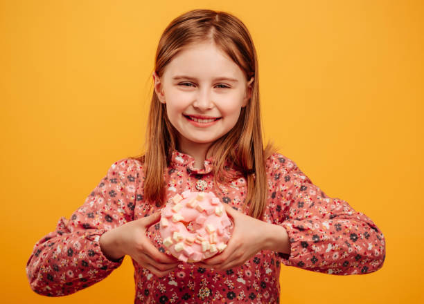 Girl with donut isolated on yellow background