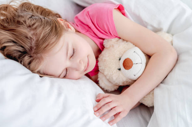 istock Girl in the bed with teddy bear 1428812595