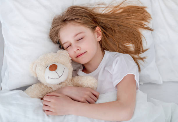 istock Girl in the bed with teddy bear 1428812603
