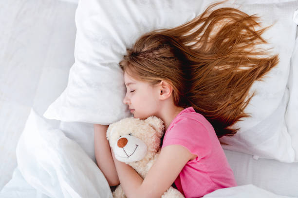 istock Girl in the bed with teddy bear 1428812615