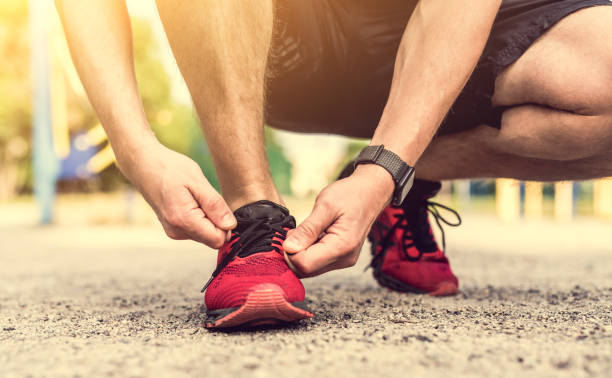 istock Man tying shoelace on red sneakers 1428814314