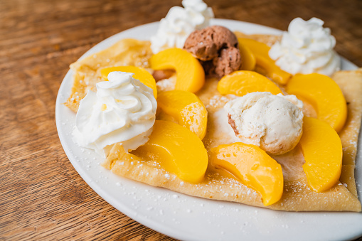 Peach Crepe with whipped cream and chocolate ice cream