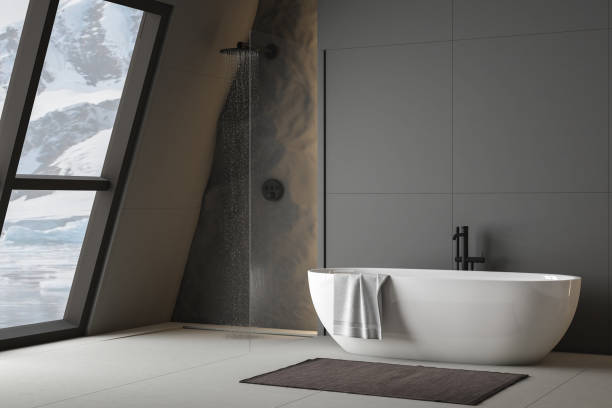 istock Modern bathroom interior with concrete floor, white oval bathtub and white basin, shower, plant and snowy mountain view from windows. Minimalist bathroom with modern furniture. 3D rendering 1428826005