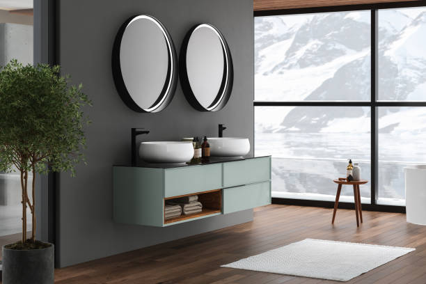 istock Modern bathroom interior with dark brown parquet floor, white oval bathtub and two sinks, side view. Minimalist bathroom with modern furniture , pool and snowy mountain view from window. 3D rendering 1428827546