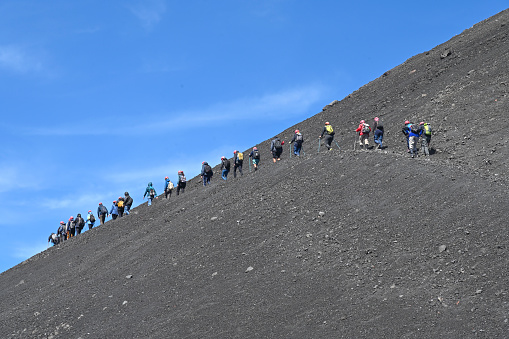 Etna, Sicily, Italy - September 19, 2022: Group of hikers along the paths of Etna.  Etna was included in the Unesco 