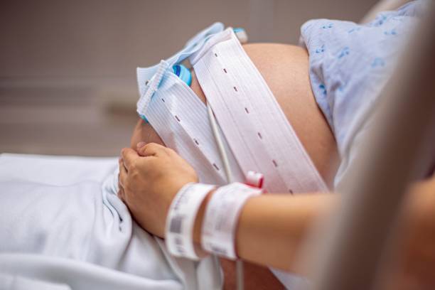 parto y trabajo de parto. una mujer embarazada en el hospital que tiene contracciones y pruebas. - equipo monitor fotografías e imágenes de stock