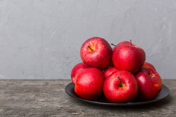 istock juicy red apples in a bowl or plate on the table top view. Copy space 1428835039